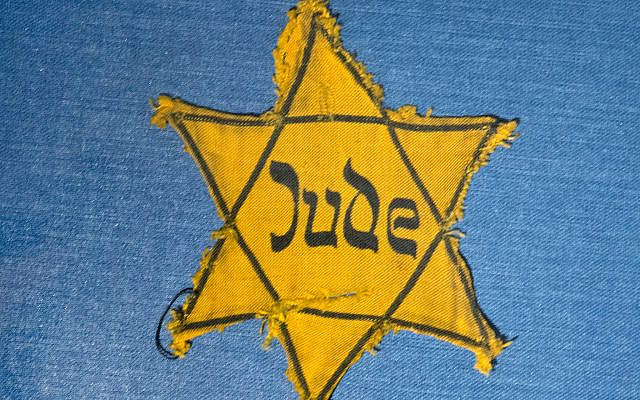 In this file photo from January 22, 2014, the Yellow Star badge of Heinz-Joachim Aris (Dresden 1941) reading 'Jew' is displayed in a showcase during a press preview in the new special exhibition 'Shoes of the Dead - Dresden and the Shoah' at the Military History Museum in Dresden, Germany. (AP Photo/Jens Meyer, file)