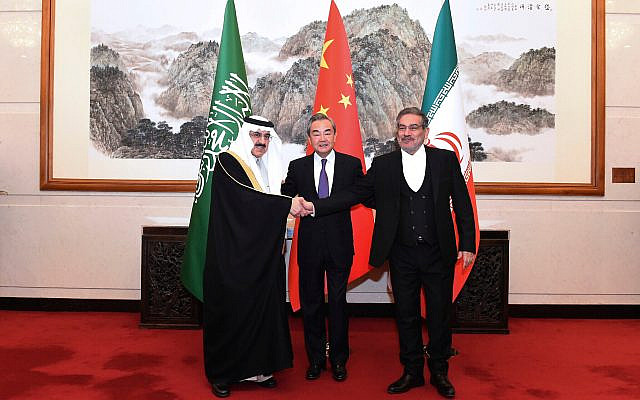 Ali Shamkhani, the secretary of Iran's Supreme National Security Council, right, shakes hands with Saudi national security adviser Musaad bin Mohammed al-Aiban, at left, as Wang Yi, China's most senior diplomat, looks on, during a photo op at a closed meeting in Beijing, China, March 11, 2023. (Luo Xiaoguang/Xinhua via AP)