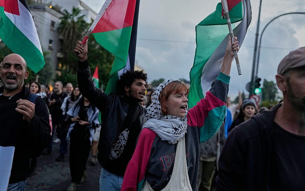 Demonstrators wave Palestinian flags outside the U.S. Embassy in Athens, Thursday, Oct. 2, 2025, to protest after a Gaza-bound aid flotilla was intercepted by the IDF in the Mediterranean Sea on Wednesday. (AP Photo/Petros Giannakouris)