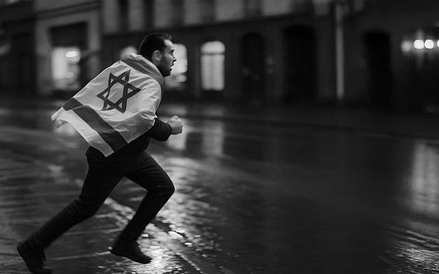 A man runs through a rain-soaked city street, clutching an Israeli flag - a fleeting image of fear amid rising hatred and hostility towards Jews. Photorealistic illustration by Sagit Alkobi Fishman, created with digital and AI tools.
