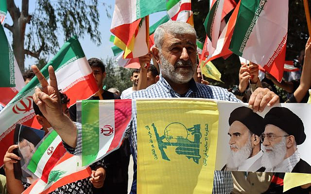 Supporters wave Iranian, Lebanese, and Hezbollah flags during a pro-Iran demonstration in South Lebanon on June 29, 2025. Shutterstock