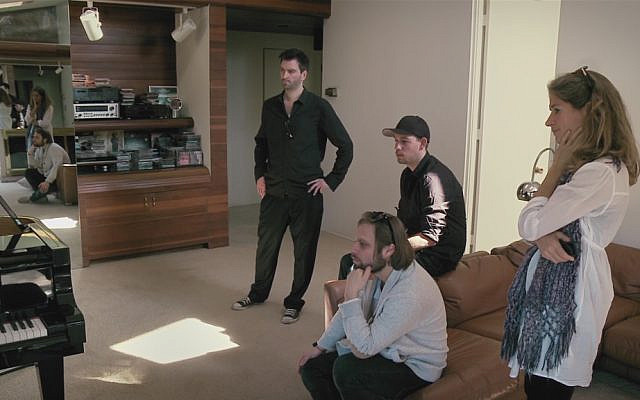 Film still from Tim Sander Goes to Hollywood, taken in William Goldstein's living room in Los Angeles in 2012 as he performs an instant composition. It features Fabian Winkelmann (left), Andreas Schaap (center), Tim Sander (on the couch), and me. Courtesy of the director.