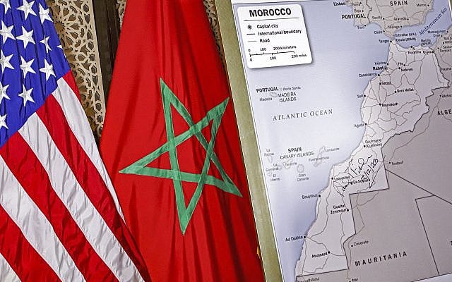 This photo (December 12, 2020) shows the Moroccan and US flags beside the US State Department map officially recognizing the Moroccan Sahara, signed by former US Ambassador David T. Fischer in Rabat. Since that recognition, Spain (2022), Israel (2023), France (2024), and the UK (2025) have followed in acknowledging the Sahara as fully Moroccan. (AFP)