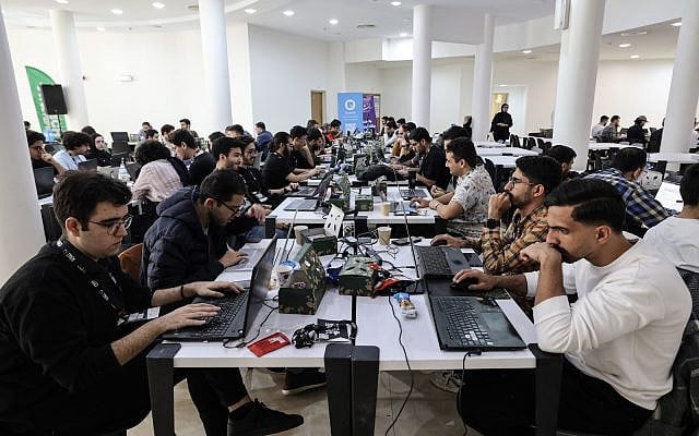 Engineering students work on artificial intelligence projects during the second edition of the International Technology Olympics held at Pardis Technology Park, on the eastern outskirts of Tehran on October 28, 2025. (ATTA KENARE / AFP)