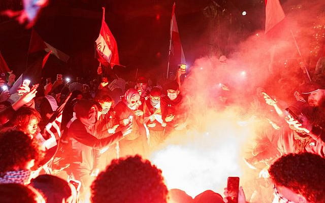 Pro-Palestine supporters set off flares and fireworks on the forecourt of the Sydney Opera House. Picture: David Swift