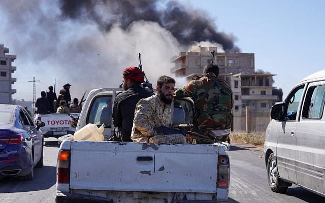 Smoke rises while Syrian security forces sit in the back of a truck as Syrian troops entered the predominantly Druze city of Sweida on Tuesday following two days of clashes, in Sweida, Syria July 15, 2025. REUTERS/Karam al-Masri     TPX IMAGES OF THE DAY