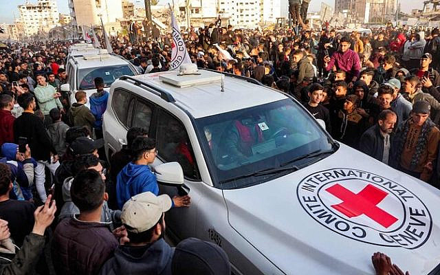 People gather around a vehicle of the International Committee of the Red Cross (ICRC) in Saraya Square in western Gaza City on January 19, 2025. The Israeli military said the Red Cross had confirmed the handover of three hostages on January 19, the first to be released as part of a ceasefire deal with Hamas. The Hostage and Missing Families Forum campaign group had identified the three women set to be released as Emily Damari, Romi Gonen and Doron Steinbrecher, seized during Hamas's October 7, 2023 attack that triggered the war. (Photo by Omar AL-QATTAA / AFP) People gather around a vehicle of the International Committee of the Red Cross (ICRC) in Saraya Square in western Gaza City on January 19, 2025. The Israeli military said the Red Cross had confirmed the handover of three hostages on January 19, the first to be released as part of a ceasefire deal with Hamas. The Hostage and Missing Families Forum campaign group had identified the three women set to be released as Emily Damari, Romi Gonen and Doron Steinbrecher, seized during Hamas's October 7, 2023 attack that triggered the war. (Photo by Omar AL-QATTAA / AFP)
