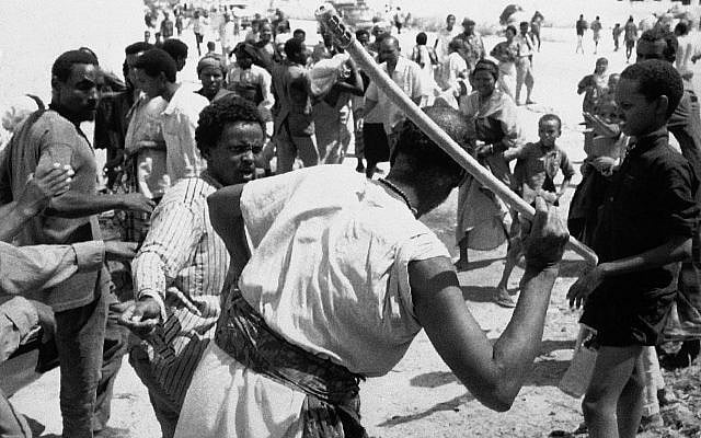 An elderly Somali man (front) fights to retain the sack of rice he has stolen from a feeding center during looting in Mogadishu, Jan. 9, 1993. (AP Photo/Greg Marinovich)