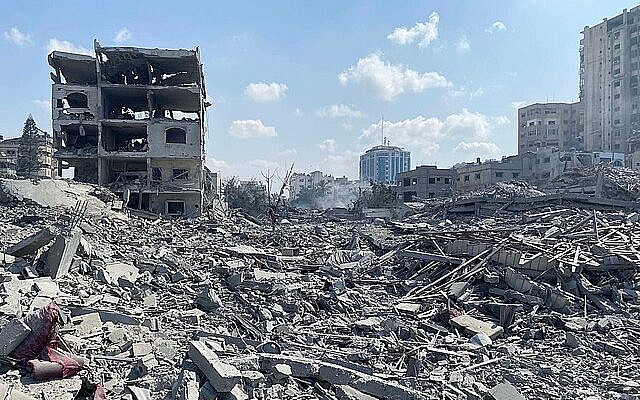 Palestinians inspect the damage following an Israeli airstrike on the El-Remal area in Gaza City on October 9, 2023. Israel continued to battle Hamas fighters on October 10 and massed tens of thousands of troops and heavy armour around the Gaza Strip after vowing a massive blow over the Palestinian militants' surprise attack. Photo by Naaman Omar apaimages