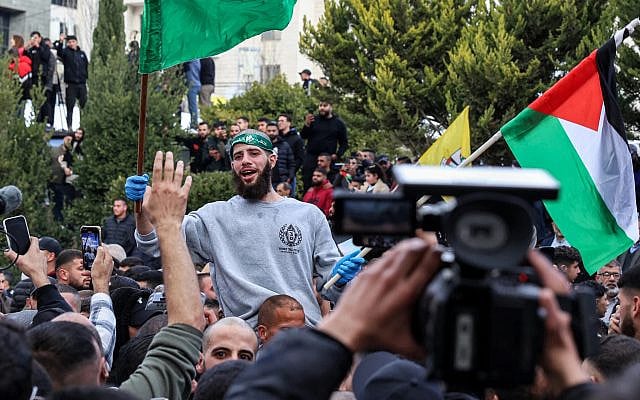 One of the Palestinian prisoners released in a hostage-ceasefire deal between Israel and Hamas reacts while being carried on people's shoulders after disembarking off one of the buses of the International Committee of the Red Cross (ICRC) upon arrival in Ramallah, January 25, 2025. (Zain Jaafar/AFP)