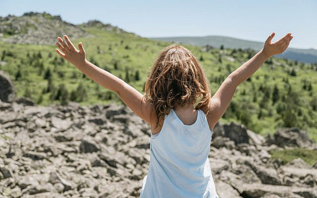 Young girl with her arms to the sky. (iStock)