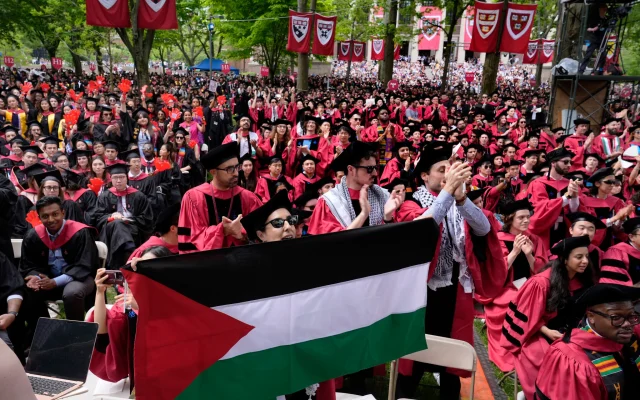 A student holds up the Palestinian flag as the 13 students, who have been barred from graduating due to protest activities, are recognized by a student address speaker during the commencement in Harvard Yard at Harvard University, May 23, 2024, in Cambridge, Massachusetts. (AP Photo/Charles Krupa)
