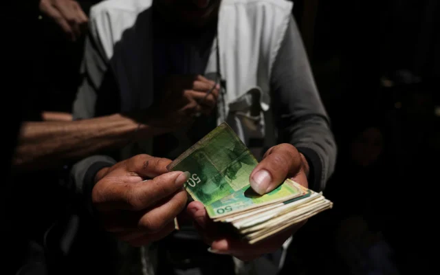 A Palestinian vegetable merchant shows worn-out Israeli currency, July 9, 2025, in Gaza City. (AP/Jehad Alshrafi) A Palestinian vegetable merchant shows worn-out Israeli currency, July 9, 2025, in Gaza City. (AP/Jehad Alshrafi)