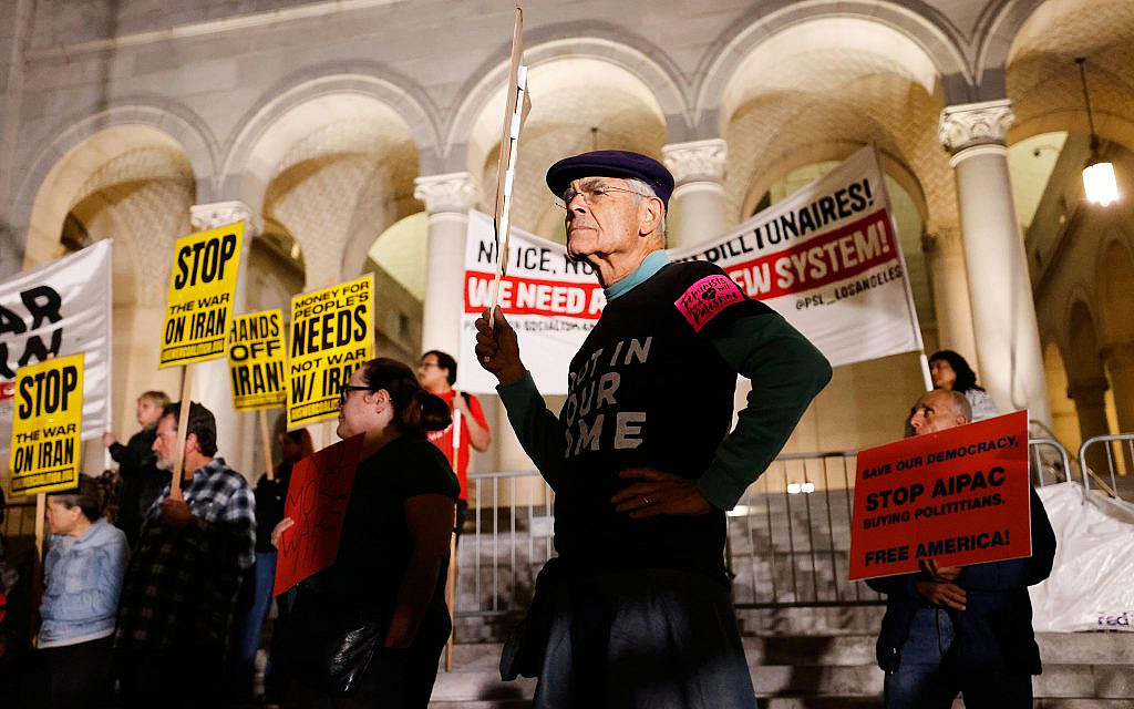 Protesters hold signs during a demonstration in reaction to the US and Israeli strikes on Iran on March 2, 2026, in Los Angeles, California. (AP Photo/ Jill Connelly)