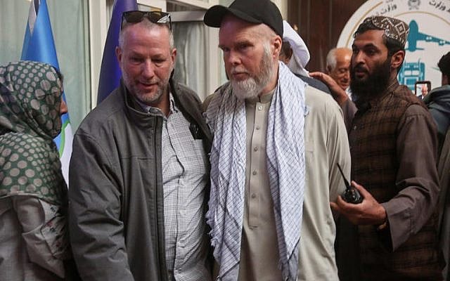 American Dennis Coyle, second from right, is accompanied by an unidentified person after being released by Afghanistan’s Taliban authorities, who had held him for over a year, before boarding a plane at the airport in Kabul, Afghanistan, Tuesday, March 24, 2026. (AP Photo/Mudassir Safi)