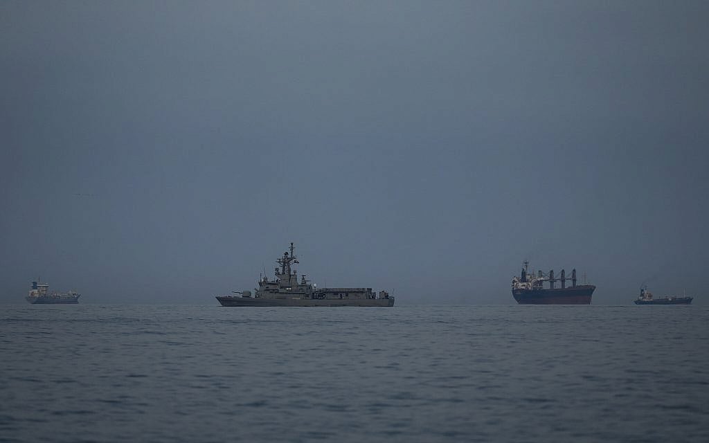 A UAE navy vessel patrols next to cargo ships and oil tankers in the Strait of Hormuz, as seen from Khor Fakkan, United Arab Emirates, on March 11, 2026. (AP/ Altaf Qadri)
