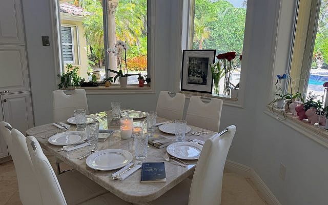 A Yom HaShoah table set at home, with candles, a family photograph, and survivor memoirs, creating space for remembrance and conversation across generations.