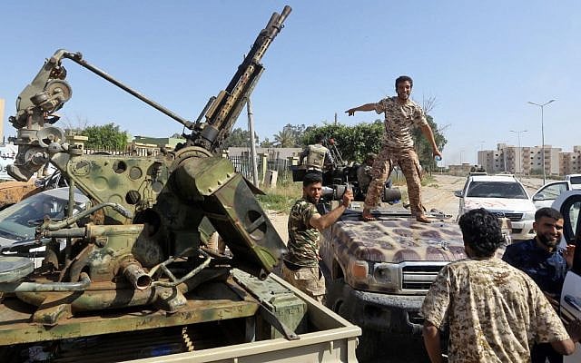 Forces loyal to Libya's Government of National Accord (GNA) gesture on April 18, 2019, after taking control of the area of al-Aziziyah, located some 40 kilometres south of the Libyan capital Tripoli, following fierce clashes with forces loyal to strongman Khalifa Haftar. - Libya's unity government issued an arrest warrant for strongman general Khalifa Haftar for allegedly ordering deadly air strikes against civilian areas. (Photo by Mahmud TURKIA / AFP)
