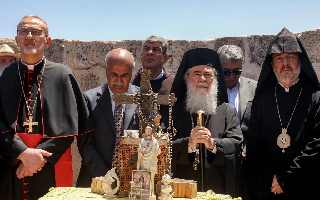 Latin Patriarch of Jerusalem Pierbattista Pizzaballa (L), Greek Orthodox Patriarch of Jerusalem Theophilos III (2nd-R), and Armenian Patriarch of Jerusalem Nourhan Manougian (R) stand together during a visit by the head clergymen of several Christian denominations to the fifth-century Church of St George in the Palestinian Christian village of Taybeh, northeast of Ramallah in West Bank on July 14, 2025, days after an arson attack on the site reportedly committed by Israeli settlers. (Zain JAAFAR / AFP)