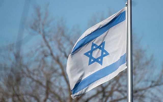 The Israeli flag featuring the Star of David against a clear blue sky and trees, picture from Pexels website (https://www.pexels.com/photo/flag-of-israel-with-star-of-david-in-blue-sky-30849038/).