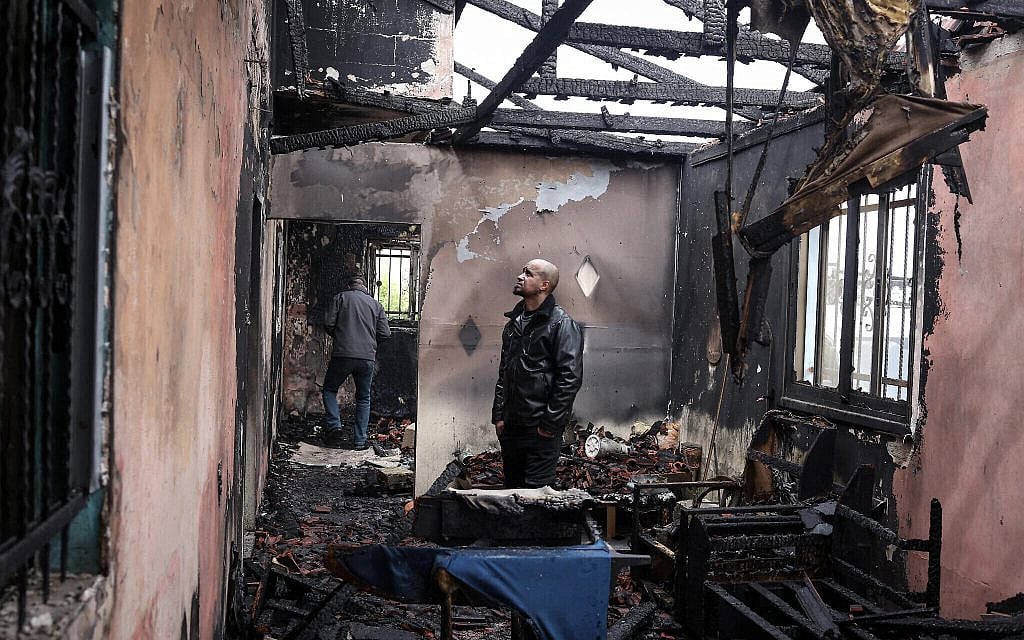 A Palestinian man inspects the remains of his burnt-out family home following a reported attack by extremist Israeli settlers in the village of Fandaqumiya, southwest of Jenin, in the West Bank on March 22, 2026. (Zain JAAFAR / AFP)