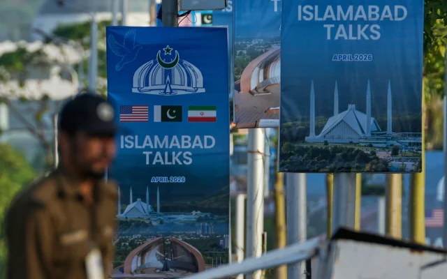 A police officer walks past posters of US and Iran talks near a possible venue in Islamabad, Pakistan, April 25, 2026. (AP Photo/Anjum Naveed)