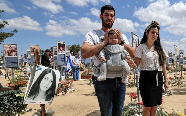 Bereaved families, friends and Israeli soldiers stand still as a two minute siren is sounded across Israel, marking Memorial Day for fallen soldiers and victims of terrorist attacks, at the site of the Nova music festival massacre, in the Re'im forest, near the Israeli-Gaza border, April 21, 2026. (Tsafrir Abayov/Flash90)