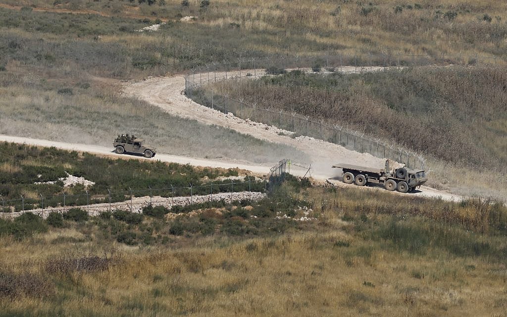 This picture, taken from a position in the Upper Galilee region in northern Israel, shows Israeli military vehicles driving along the road in southern Lebanon near the border with Israel on June 4, 2026. (Jalaa MAREY / AFP)
