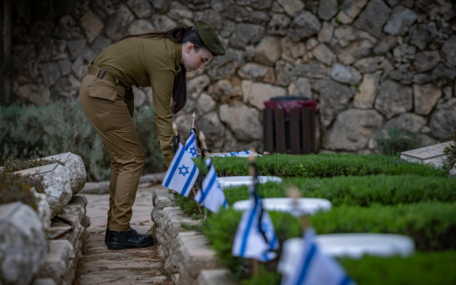 IDF soldiers place Israeli flags on graves of soldiers during the flag laying ceremony in Mount Herzl Military Cemetery in Jerusalem, on April 19, 2026, ahead of Memorial Day. (Yonatan Sindel/Flash90)