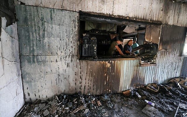Palestinian men inspect the aftermath inside a restaurant after it was burned down by settlers during an attack in the western area of the Al-Lubban ash-Sharqiya village, south of Nablus, in the West Bank on on July 5, 2026. (Photo by JAAFAR ASHTIYEH / AFP)