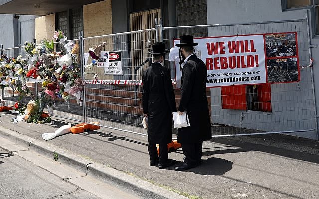 People gather outside the Adass Israel Synagogue, December 9, 2024, after a firebombing in Melbourne, Australia. (Con Chronis/AAP Image via AP)