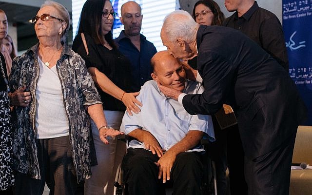 Former Israeli president Shimon Peres kisses Surin Hershko at an event marking 40 years since Operation Entebbe, held, on June 27, 2016. (Ben Kelmer/FLASH90 BEN)