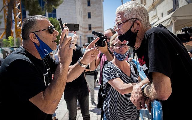 Supporters of Prime Minister Benjamin Netanyahu argue with "Crime Minister" activists outside the Jerusalem Magistrate's Court on August 2, 2020. Photo by Yonatan Sindel/Flash90