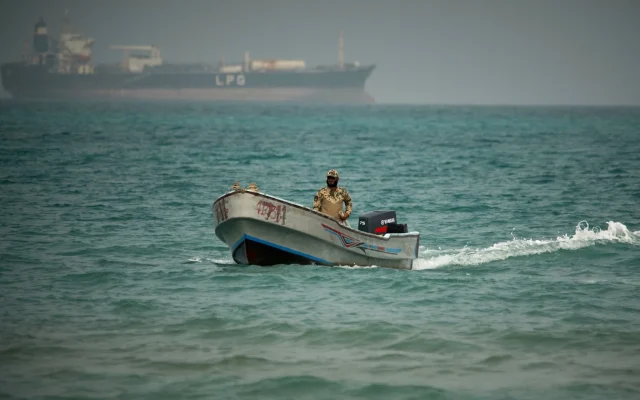 Backdropped by an LPG (liquefied petroleum gas) tanker, a Yemeni soldier sails in waters north of the Bab el-Mandeb Strait in Mokha, Yemen, April 6, 2026 (AP Photo/Abdulnasser Alseddik)