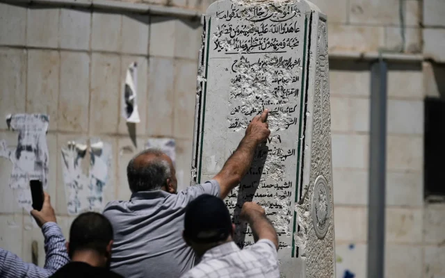 People look at a damaged "Martyrs Monument" in the West Bank village of Madama after far-right Religious Zionism MK Zvi Sukkot smashed it, August 25, 2026. (AP Photo/Majdi Mohammed)