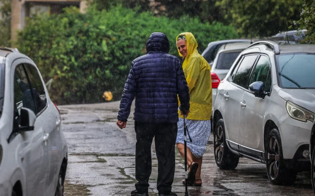 People walk in the rain in Jerusalem, August 15, 2026. (Yossi Zamir/Flash90)