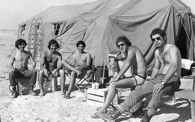 IDF reservists sunning themselves outside their tent on the western bank of the Suez Canal during the 1973 Yom Kippur War (Government Press Office) IDF reservists sunning themselves outside their tent on the western bank of the Suez Canal during the 1973 Yom Kippur War (Government Press Office)