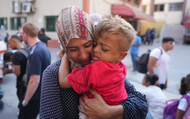 A Palestinian woman says goodbye to her sick son before he departs the Gaza Strip to get treatment abroad through the Kerem Shalom crossing, in Khan Younis, southern Gaza Strip, as part an initiative led by the World Health Organization for 21 children to receive life-saving treatment elsewhere, June 27, 2024. (AP Photo/Abdel Kareem Hana)