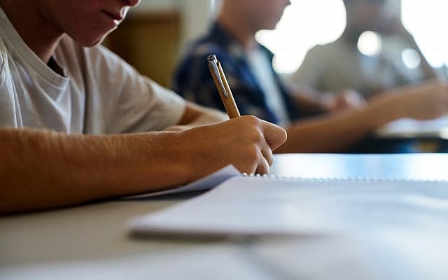 Young men writing essays. (iStock)
