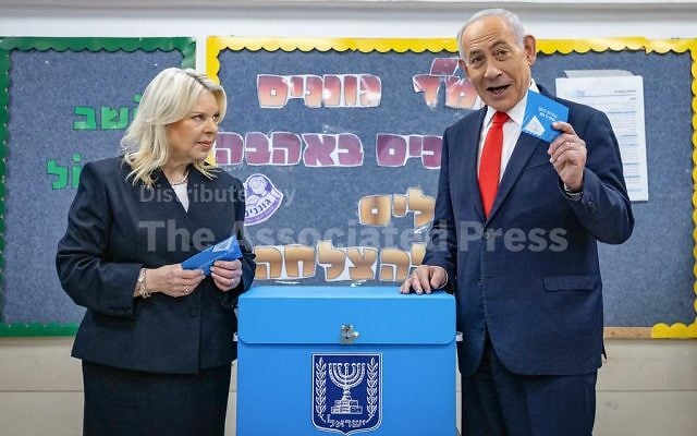 Israel's Prime Minister Benjamin Netanyahu prepares to cast his ballot, alongside his wife Sara, at a polling station in Jerusalem, Tuesday, Oct. 27, 2026. (Yonatan Sindel/Pool Photo via AP)