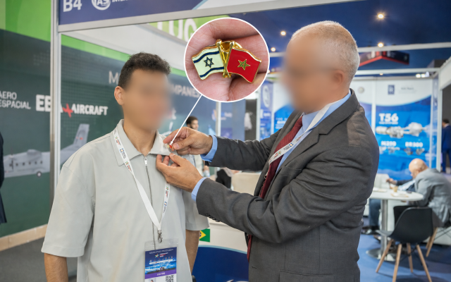 An Israeli official fastens a Morocco-Israel friendship pin to my shirt at Marrakech Airshow 2026. Both faces are blurred for privacy, given the sensitivity surrounding Israeli participation.