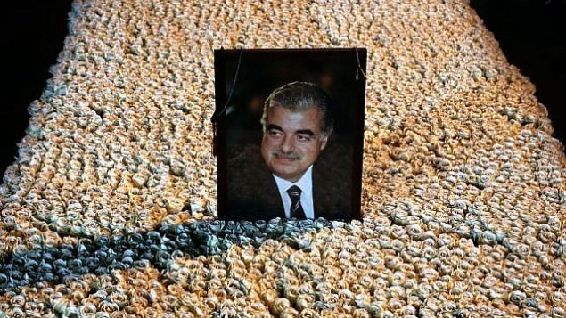 توضیح تصویر: پرتره‌ی رافیک حریری نخست وزیر مقتول لبنان بر مقبره‌ی پوشیده از گل در مرکز شهر بیروت، لبنان، ۱۵ ژانویه‌ ۲۰۱۴. (AP/Hussein Malla)