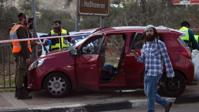 تصویر: کارکنان پزشکی قانونی اسرائیل اتوموبیلی در حوالی محل حمله در نزدیکی تقاطع آریل در کرانه باختری را مورد تجسس قرار داده اند، ۱۷ مارس ۲۰۱۹. (JAAFAR ASHTIYEH / AFP)