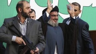 در عکسی از ۱۷ سپتامبر ۲۰۱۲، «حسن نصرالله» رهبر حزب الله، وسط، در میان بادیگاردهای خود، برای جمعیت دههاهزار نفری حامیان در راهپیمایی بیروت، لبنان، دست تکان میدهد. (AP Photo/Hussein Malla, File)
