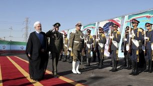 تصویر: در عکسی که در وبسایت رسمی دفتر ریاست جمهوری ایران منتشر شد، حسن روحانی رئیس جمهور ایران، چپ، بهمراه سرتیپ امیر حاتمی، وزیر دفاع، در مراسم رونمایی از سامانه دفاع موشکی «باور۳۷۳»، از گارد احترام سان می بیند، سه شنبه، ۲۲ اوت ۲۰۱۹، ایران. (Iranian Presidency Office via AP)