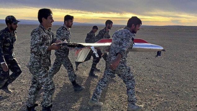 تصویر: در عکسی که در ۵ نوامبر ۲۰۱۸ از سوی ارتش ایران عرضه شد، در یکی از تمرینات نظامی در سمنان، ایران، سربازان در حال حمل قطعه ای از پهبادی که سقوط کرده دیده میشوند. (Iranian Army via AP) تصویر: در عکسی که در ۵ نوامبر ۲۰۱۸ از سوی ارتش ایران عرضه شد، در یکی از تمرینات نظامی در سمنان، ایران، سربازان در حال حمل قطعه ای از پهبادی که سقوط کرده دیده میشوند. (Iranian Army via AP)
