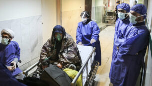 FILE - In this March 7, 2020 file photo, a patient infected with the new coronavirus is moved, at Baqiyatallah Al'Azam Hospital that is affiliated to the Revolutionary Guard, in Tehran, Iran. While crippling sanctions imposed by the U.S. government left the country ill-equipped to deal with the fast-moving virus, some medical professionals say government and religious leaders bear the brunt of the blame for allowing the virus to spread -- and for hiding how much it had spread. (Mohammad Hasan Zarifmanesh/Tasnim News Agency via AP, File)