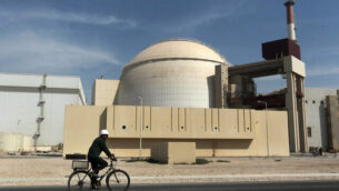 FILE - In this Oct. 26, 2010 file photograph, a worker rides a bicycle in front of the reactor building of the Bushehr nuclear power plant, just outside the southern city of Bushehr. Iran's deputy foreign minister said Thursday, Jan 31, 2019, that he believes European Union nations soon will announce they've created a program for Iran to continue trade there and avoid re-imposed U.S. sanctions over its nuclear program. (AP Photo/Mehr News Agency, Majid Asgaripour, File)