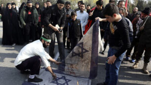 Protesters burn representations of Israeli flag during a demonstration over the U.S. airstrike in Iraq that killed Iranian Revolutionary Guard Gen. Qassem Soleimani, in Tehran, Iran, Jan. 3, 2020. Iran has vowed "harsh retaliation" for the U.S. airstrike near Baghdad's airport that killed Tehran's top general and the architect of its interventions across the Middle East, as tensions soared in the wake of the targeted killing. (AP Photo/Vahid Salemi)