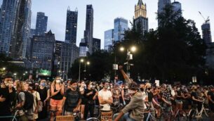 Protesters block traffic en route to the Brooklyn Bridge and downtown Manhattan beside an encampment outside City Hall, Tuesday, June 30, 2020, in New York. New York City lawmakers were expected Tuesday to approve shifting $1 billion from policing to education and social services in the coming year, acknowledging protesters' demands to cut police spending — but falling short of what activists sought. (AP Photo/John Minchillo)